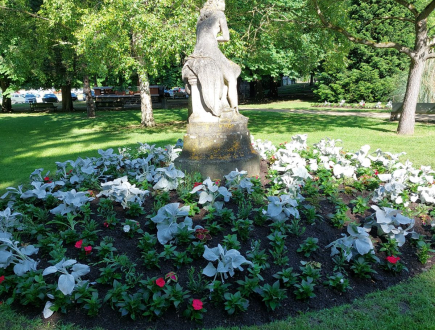 Photographie d'un massif de fleurs entourant une statue dans le Square Bezard à Meulan en Yvelines 