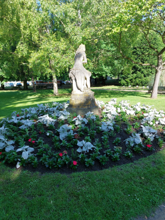Photographie d'un massif de fleurs entourant une statue dans le Square Bezard à Meulan en Yvelines 